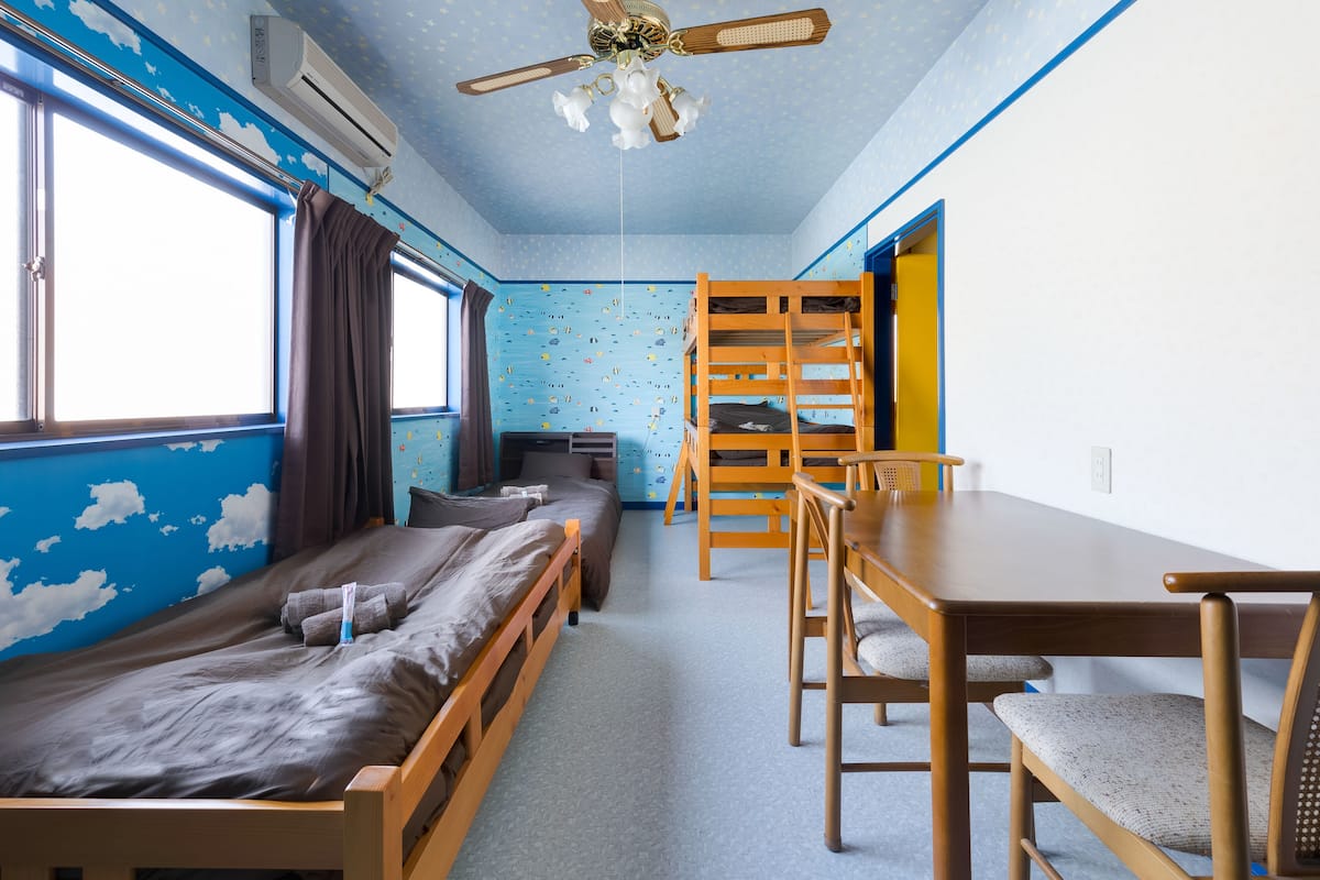 Un dormitorio con literas, un escritorio y una silla.
