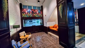 A hotel lobby with a seating area, a reception desk, and a colorful wall mural. - Sanctuary Hotel Yangon (Yangon)