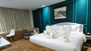 A hotel room with a bed, a desk, a chair, and a window with curtains. - Sanctuary Hotel Yangon (Yangon)