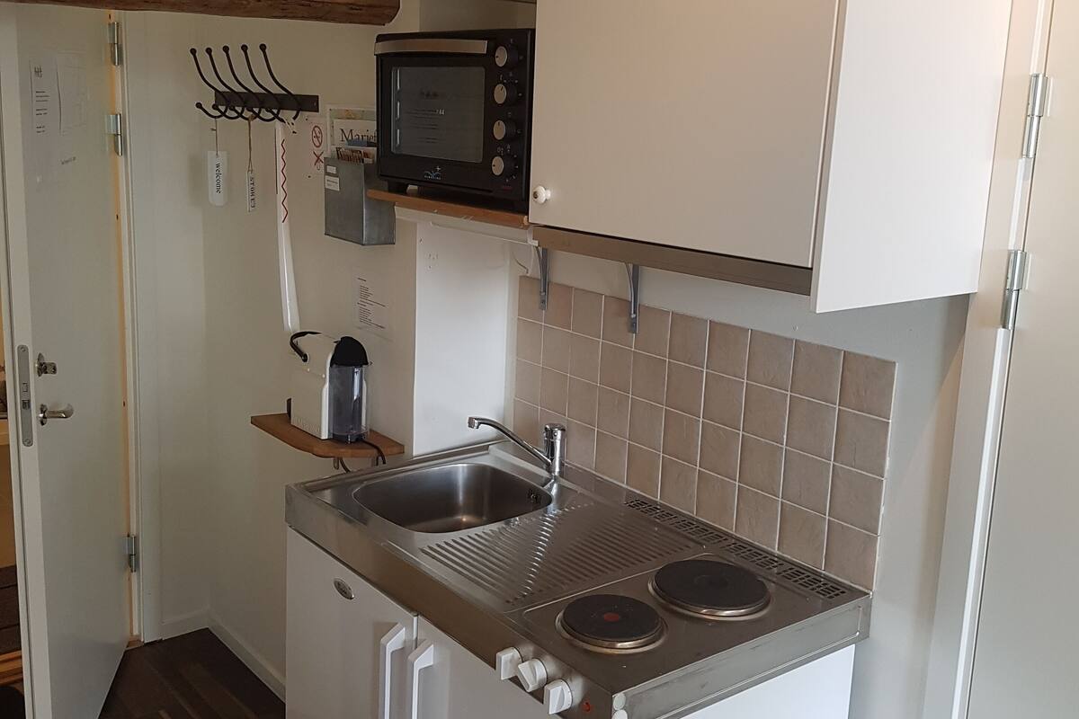 A compact kitchen with a built-in microwave, a sink, and a stove.