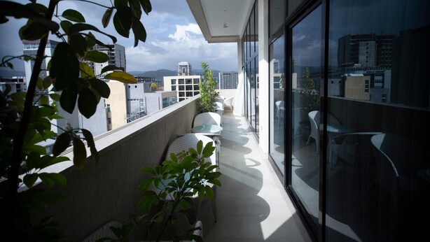 A balcony with a view of city buildings and a clear sky. - Daamat Hotel (Addis Ababa)