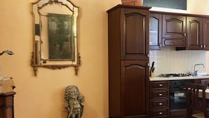 Una cocina con armarios de madera oscura, un protector contra salpicaduras de azulejos y una estatua de piedra en el suelo.