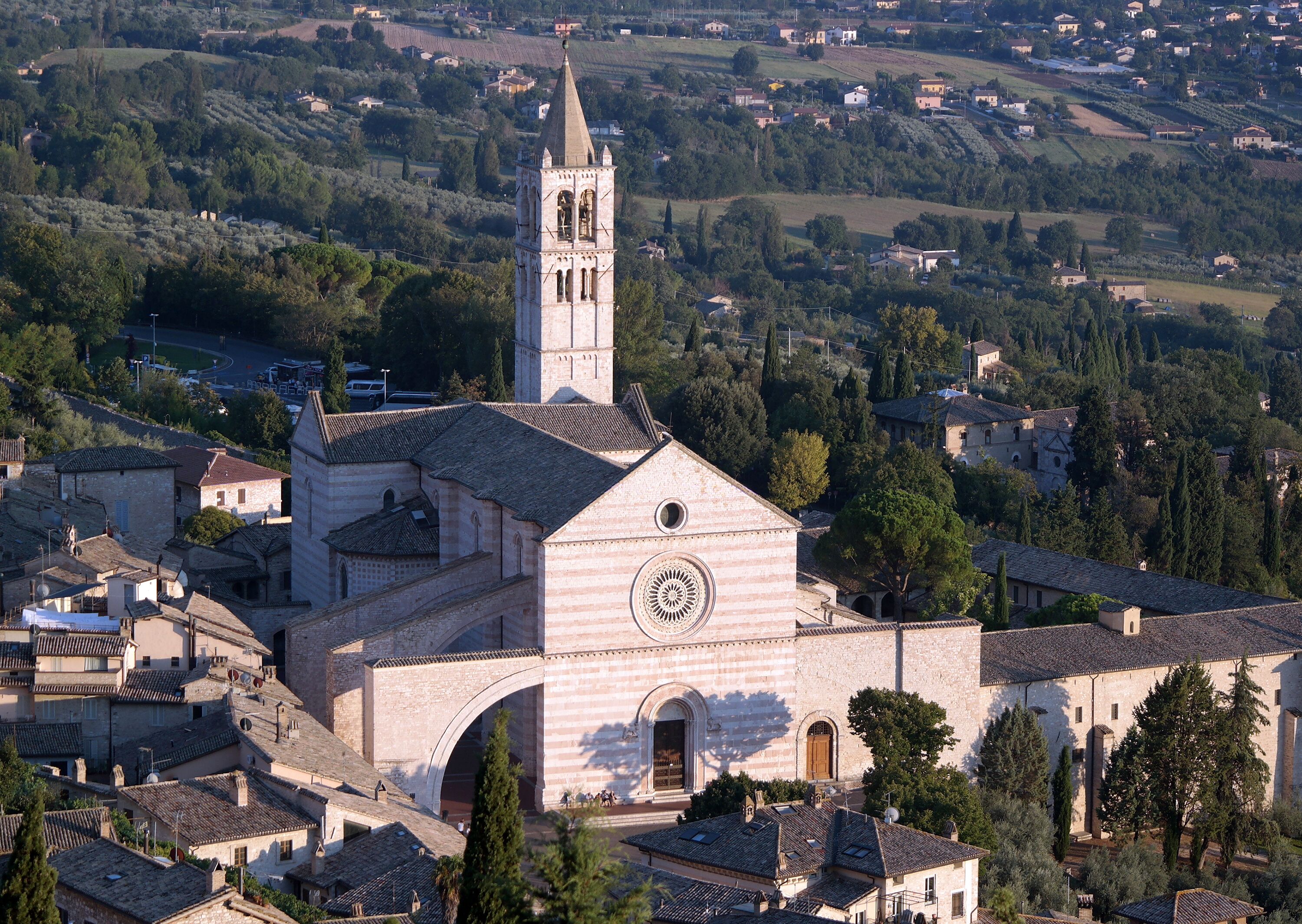 A historic church with a bell tower, arched entrance, and a circular window.