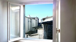 A window with a view of a narrow street with traditional buildings. - Camere Gambacorta (Assisi)