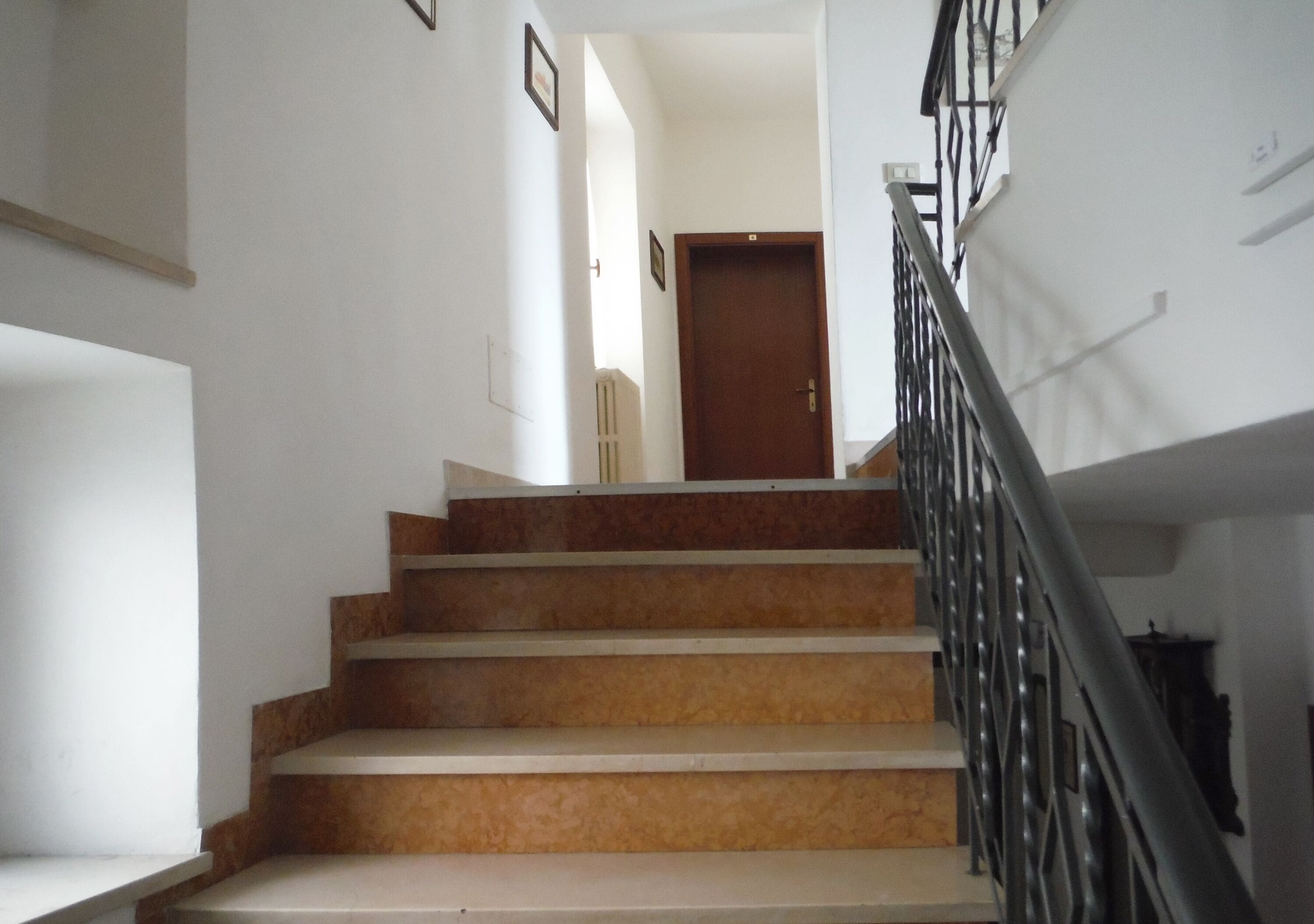 A staircase with a handrail, leading to a door at the top.