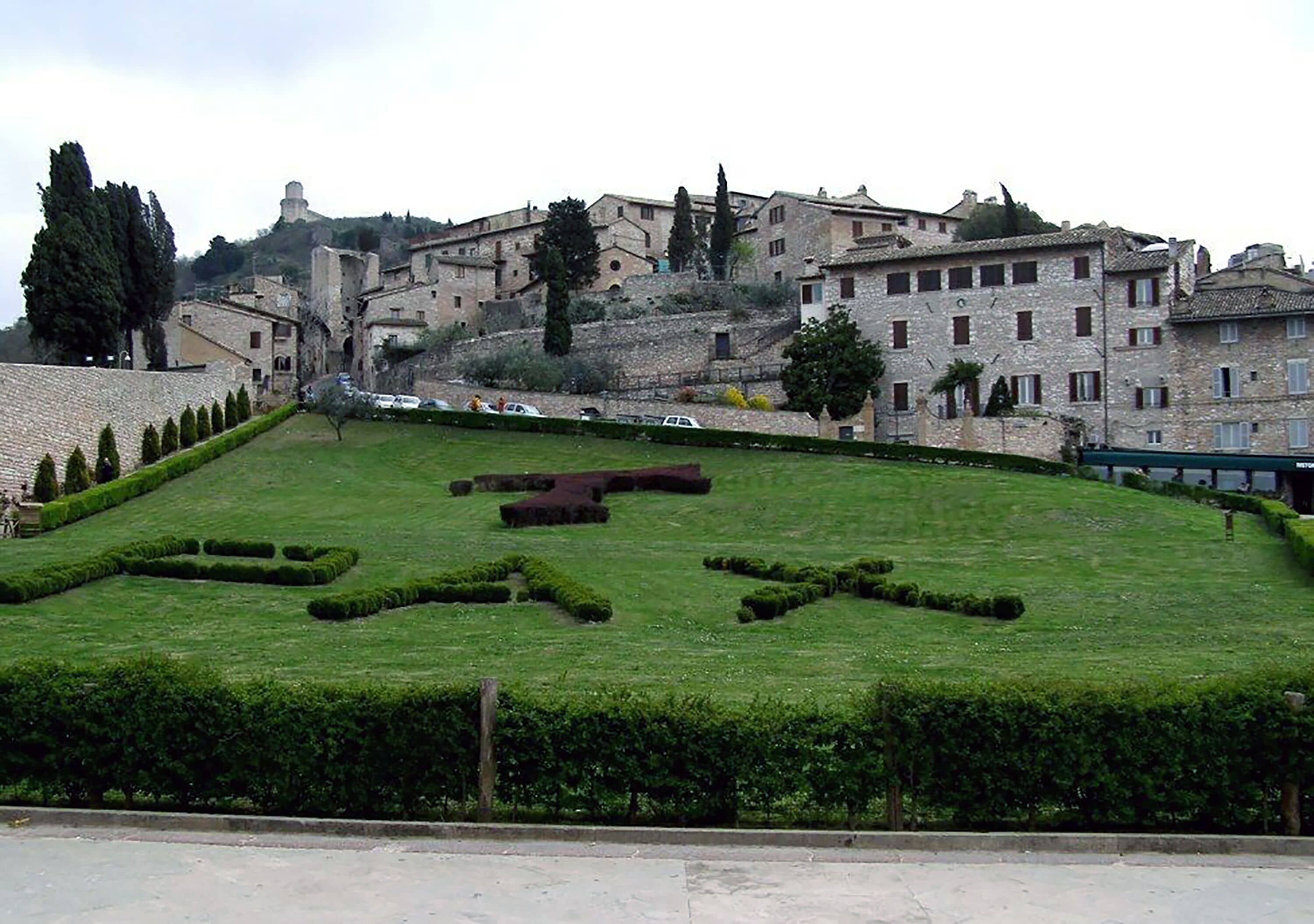 A well-maintained lawn with geometric shapes and a stone wall in the foreground.