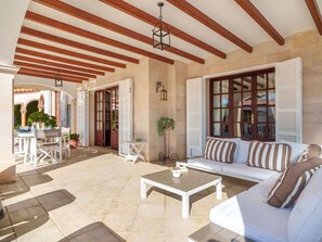 A spacious patio with a white sofa, a coffee table, and a dining area with a table and chairs. - Beautiful private villa for 6 people with private pool, A/C, WIFI, TV, terrace and panoramic view (Manacor)