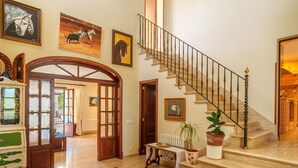 A spacious foyer with a marble floor, a grand staircase, and a large wooden door leading to another room. - Beautiful private villa for 6 people with private pool, A/C, WIFI, TV, terrace and panoramic view (Manacor)