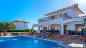 A poolside area with a large pool, sun loungers, and a covered patio with outdoor furniture. - Nice apartment for 4 guests with pool, WIFI, TV and terrace (Manacor)