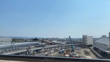 Una obra en construcción con maquinaria pesada y un edificio grande al fondo.