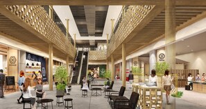 A spacious indoor area with a central staircase, seating areas, and various shops.