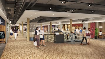 A modern indoor shopping area with a wooden floor, escalators, and various stores including a restaurant named 'SIGN'.