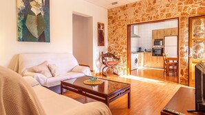 Una sala de estar con sofá, mesa de centro y un cuadro en la pared.