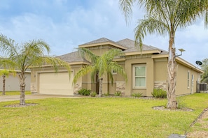A residential house with a garage, palm trees, and a well-maintained lawn. - Laguna Vista Resort-Style Home, Private Pool & Spa (Laguna Vista)