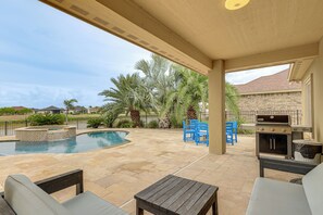 Un espace extérieur abrité comprenant une piscine, du mobilier de jardin et un barbecue.