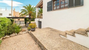 Une maison moderne à l’extérieur blanc, dotée d’un escalier en pierre et d’un chemin de gravier.