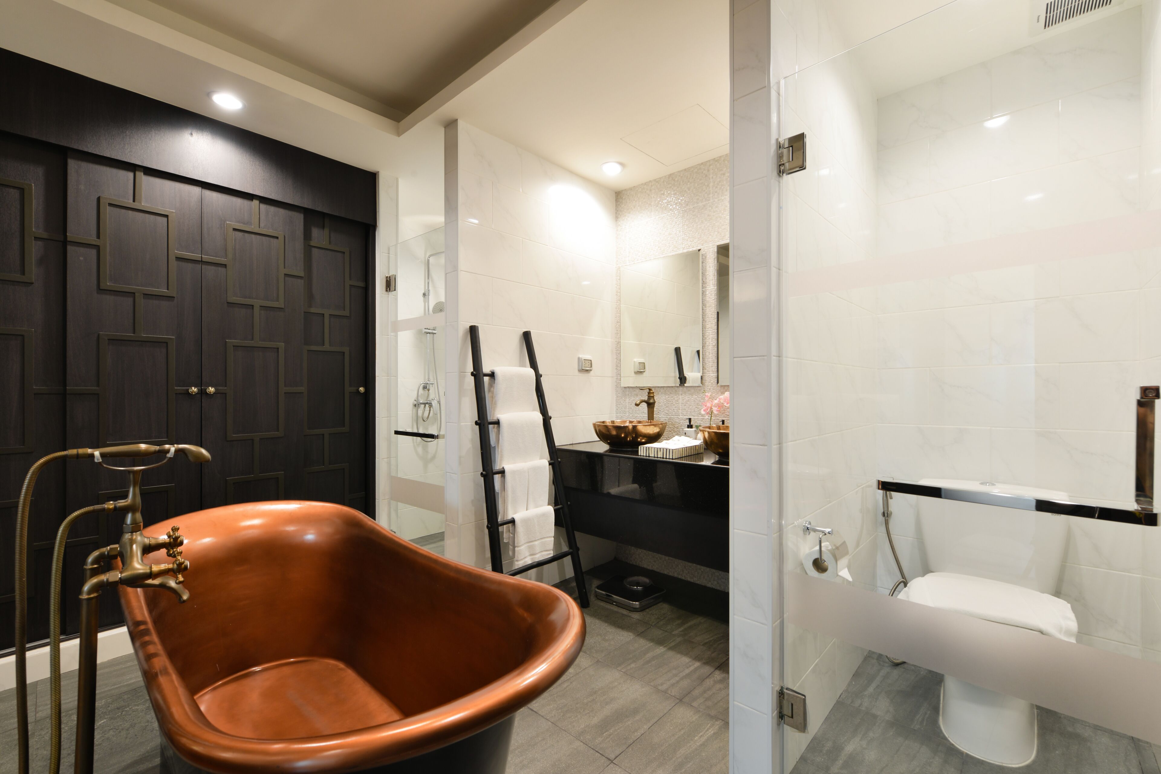 Un baño con una bañera independiente, un lavamanos moderno y un inodoro.