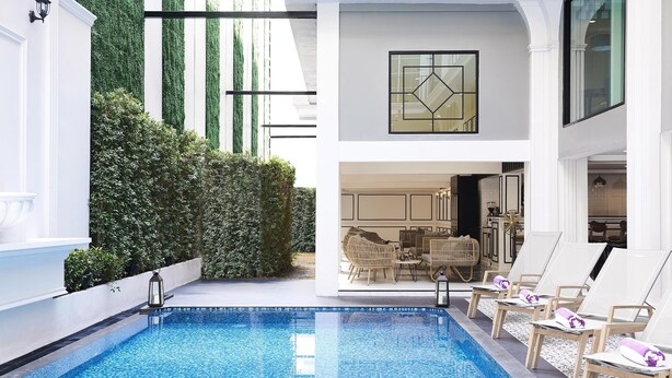 Un área de piscina interior moderna con vista despejada hacia un comedor al fondo.