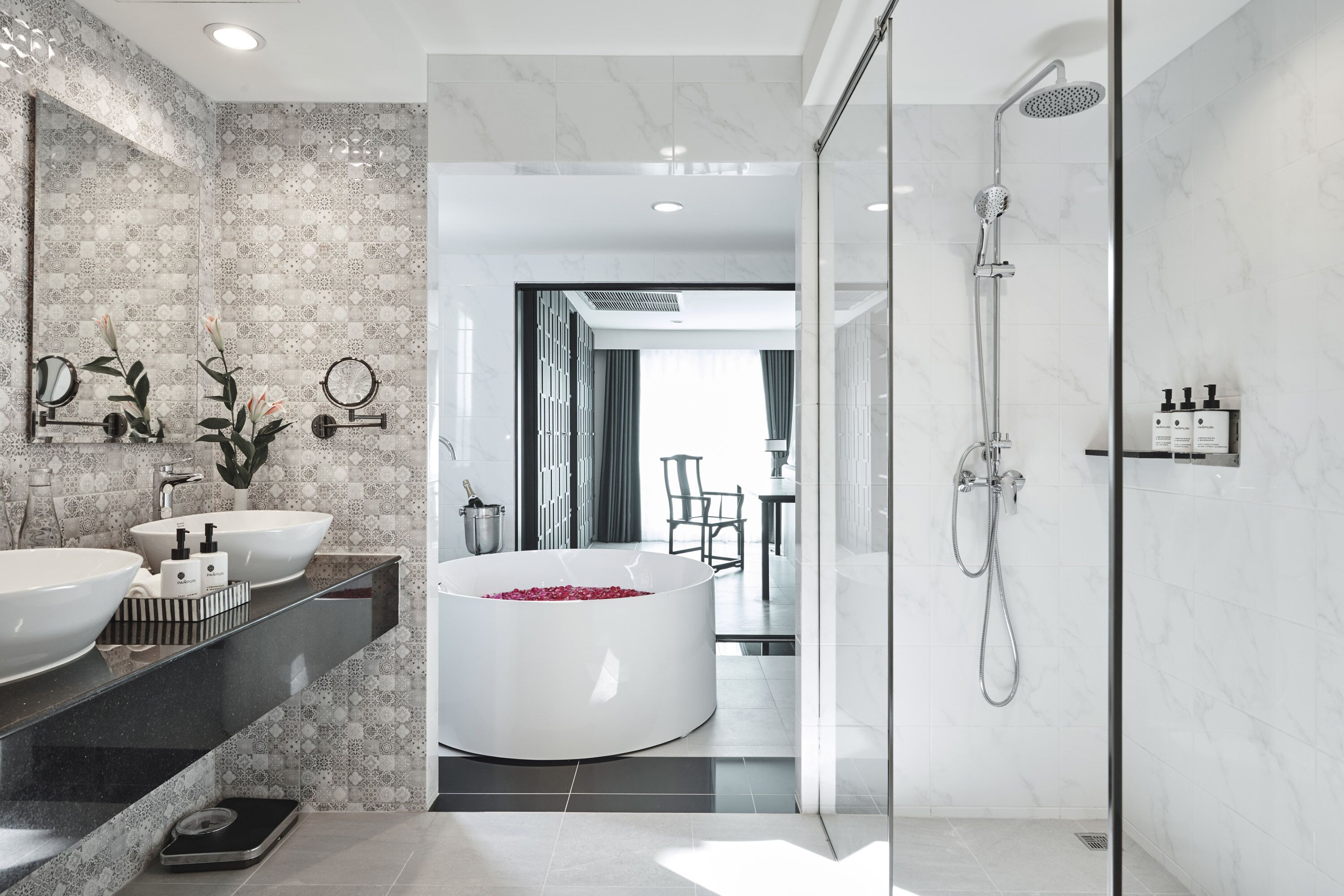 A modern bathroom with two sinks, a large bathtub, and a shower.