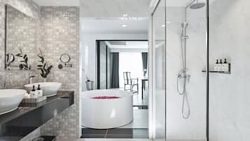 A modern bathroom with two sinks, a large bathtub, and a shower.