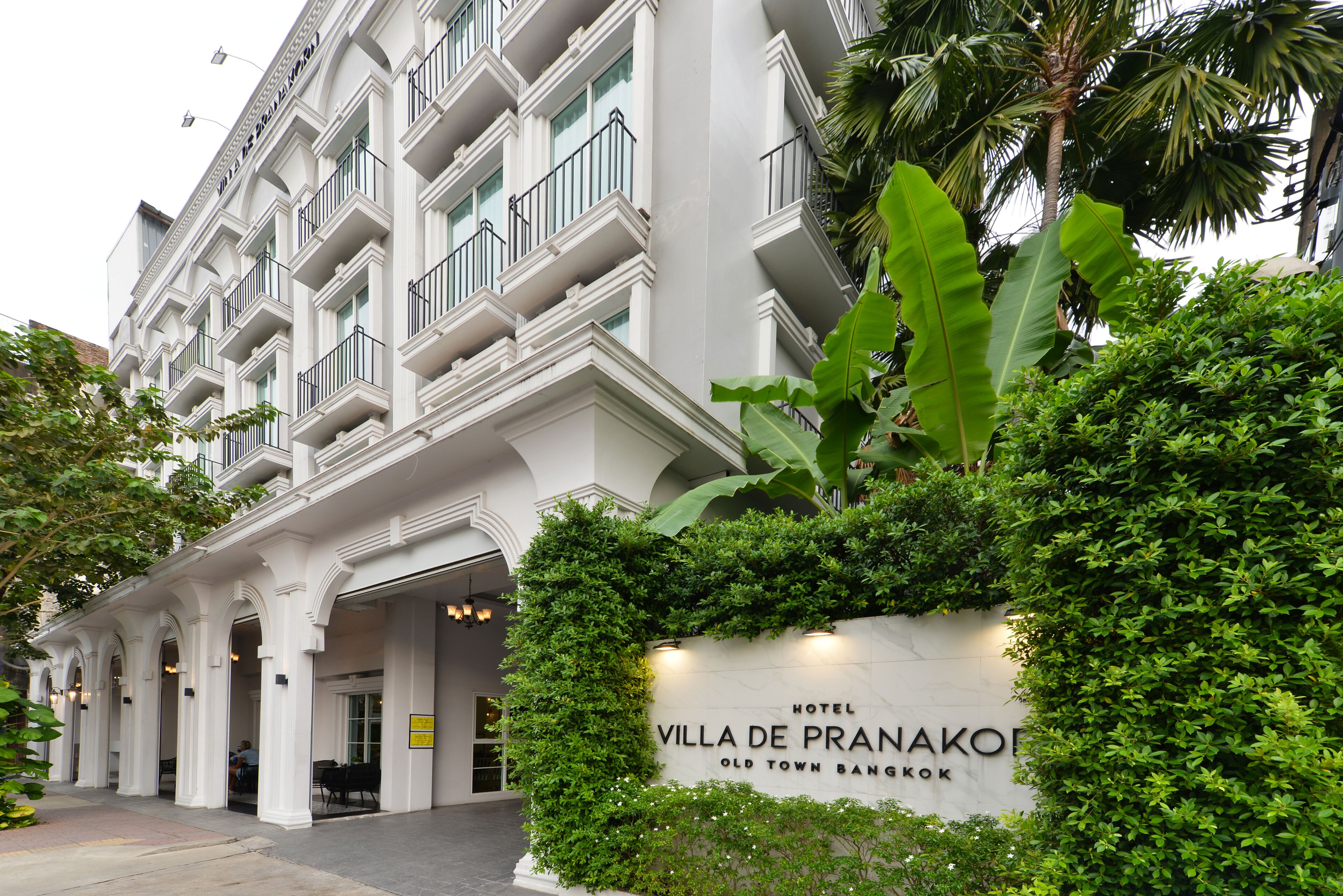 A hotel facade with a sign reading "Villa De Pranakorn Old Town Bangkok."
