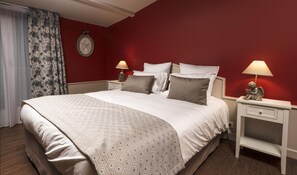 A hotel room with a large bed, two bedside tables, a nightstand, a wall clock, and a window with curtains. - Logis Hotel le Cedre de Soyons (Soyons)