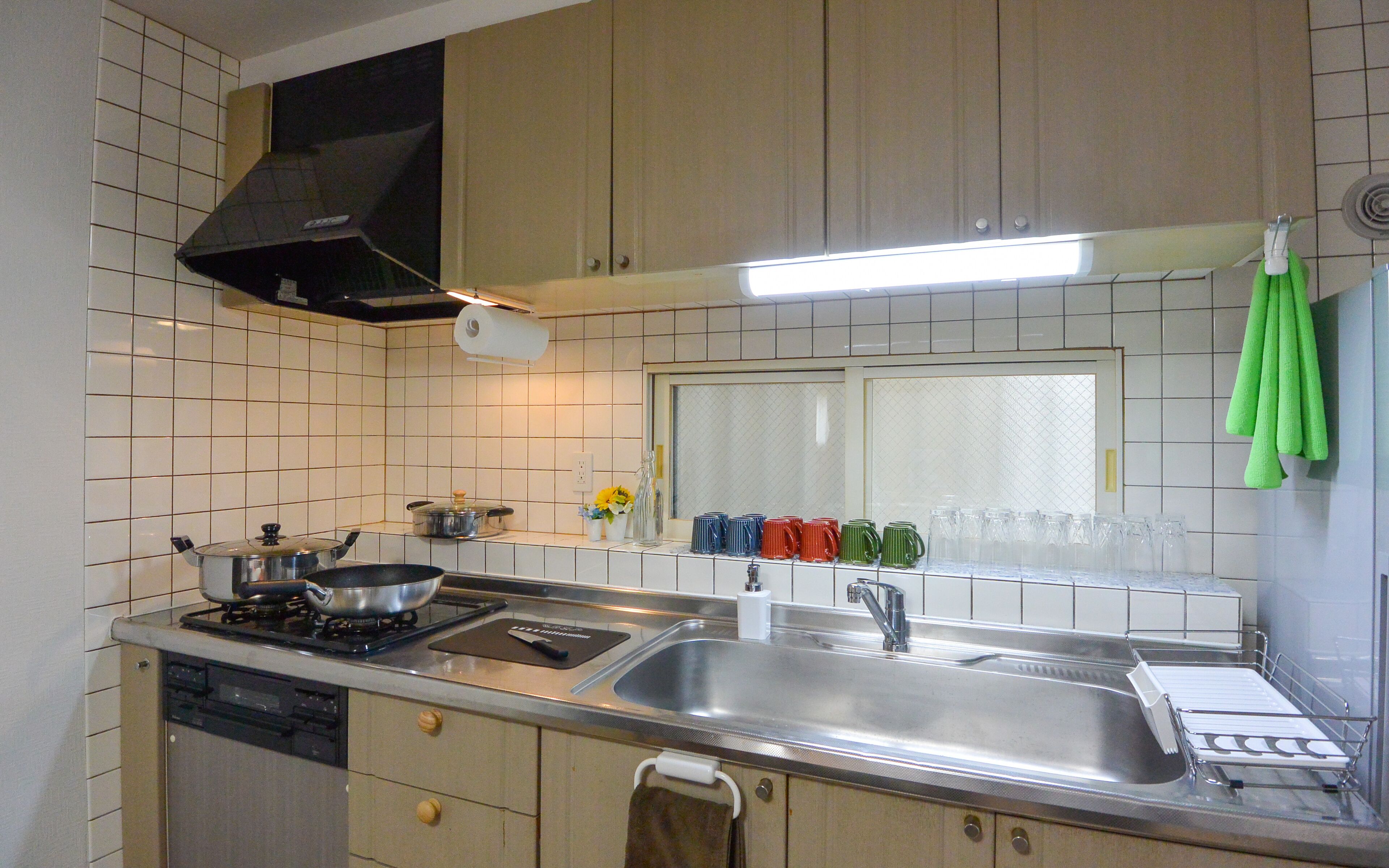 A kitchen with a stove, sink, and cabinets.