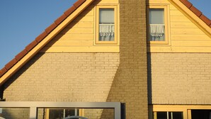 A two-story building with a brick facade and a gabled roof. - Cozy vacation home in Julianadorp Strandslag (Julianadorp)