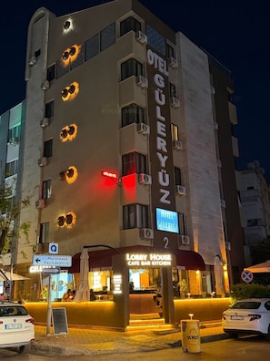 A hotel named 'GULERYUZ' with a lobby house, cafe bar kitchen, and a sign indicating a nearby Muratpasa and Kaymakamlı area. - Güleryüz 2 Hotel (Antalya)