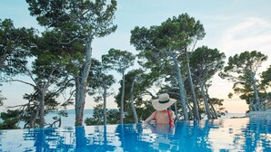 A person in a swimming pool with trees in the background. - Bluesun Mala Berulia (Brela)