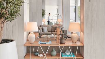 A modern living room with a sofa, two lamps, a coffee table, and decorative items on shelves.