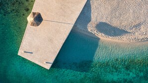 An aerial view of a beach with a paved walkway leading to the water. - Bluesun Mala Berulia (Brela)