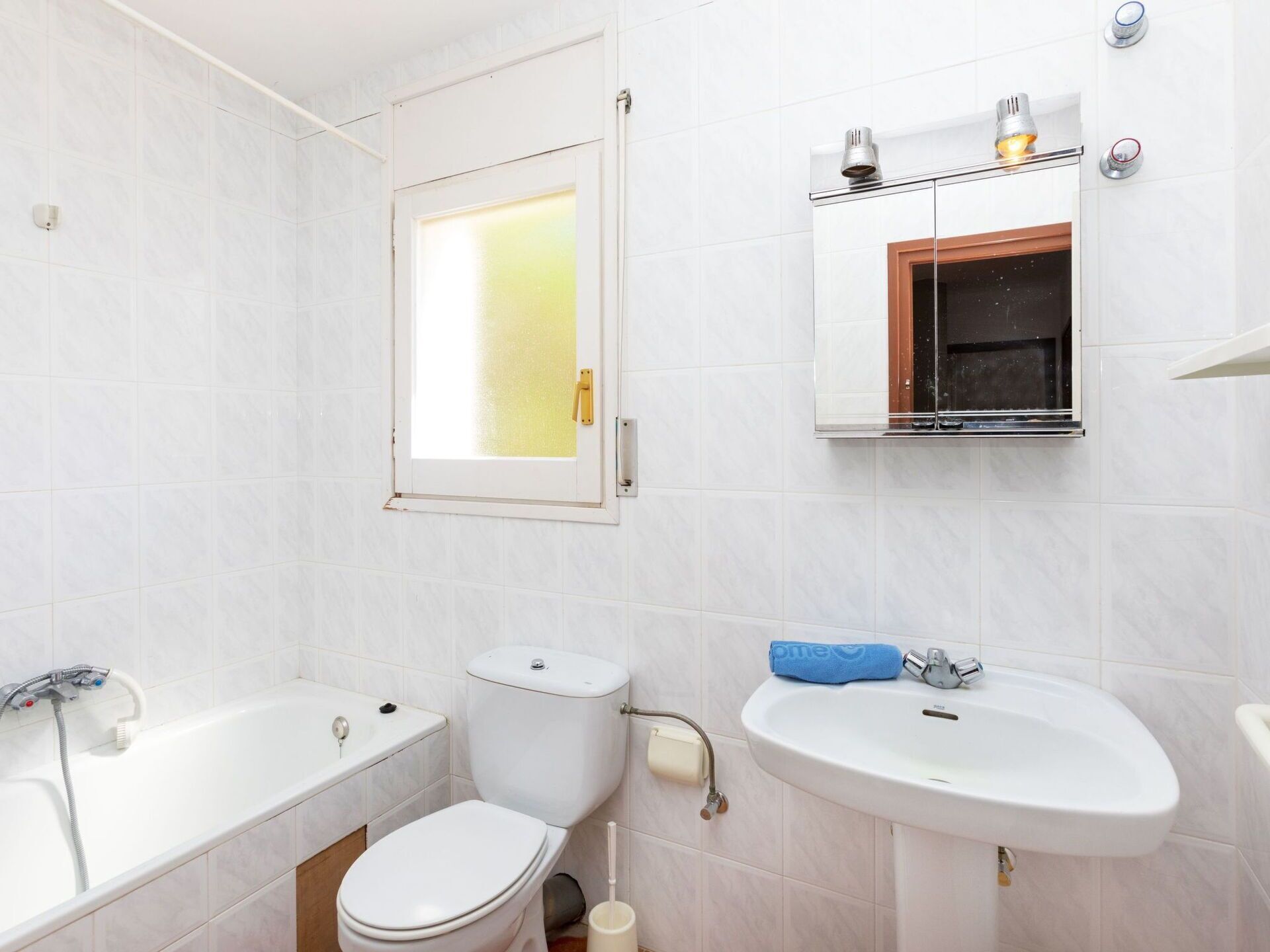 A bathroom with a toilet, bathtub, and sink.
