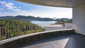 A balcony with a view of a lake and mountains. - Sosiega Hue Pension (Goheung)