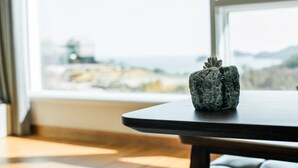 A stone sculpture on a table near a window with a view of a cityscape. - Sosiega Hue Pension (Goheung)