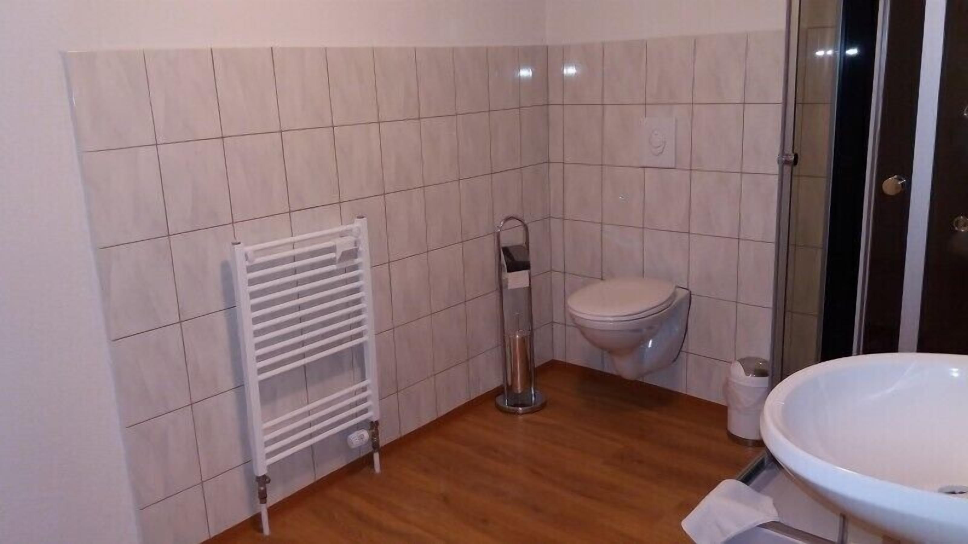 Ein Badezimmer mit Waschbecken, Toilette und einem weißen Handtuchhalter.