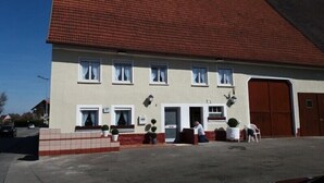 A two-story house with a red-tiled roof, multiple windows, and a garage door. - Apartments B & B27 (Rottweil)