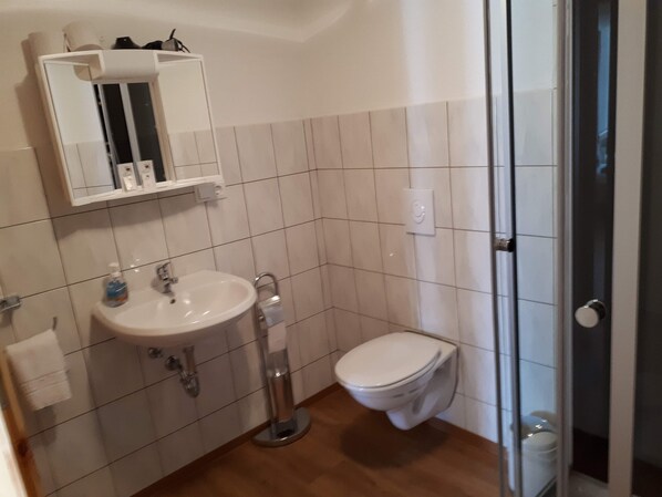 A small, clean bathroom with a white sink, mirror, and toilet. - Apartments B & B27 (Rottweil)