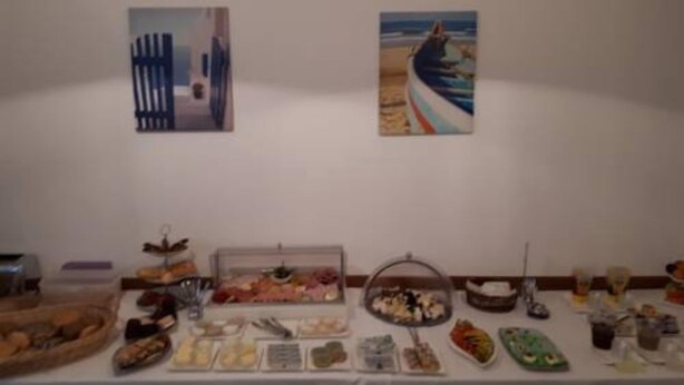 A buffet table with various food items and two paintings on the wall above. - Apartments B & B27 (Rottweil)