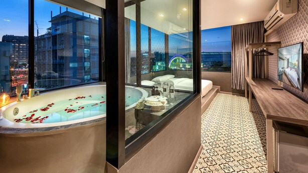 Uma casa de banho moderna com banheira, toucador e uma janela ampla com vista para a cidade.