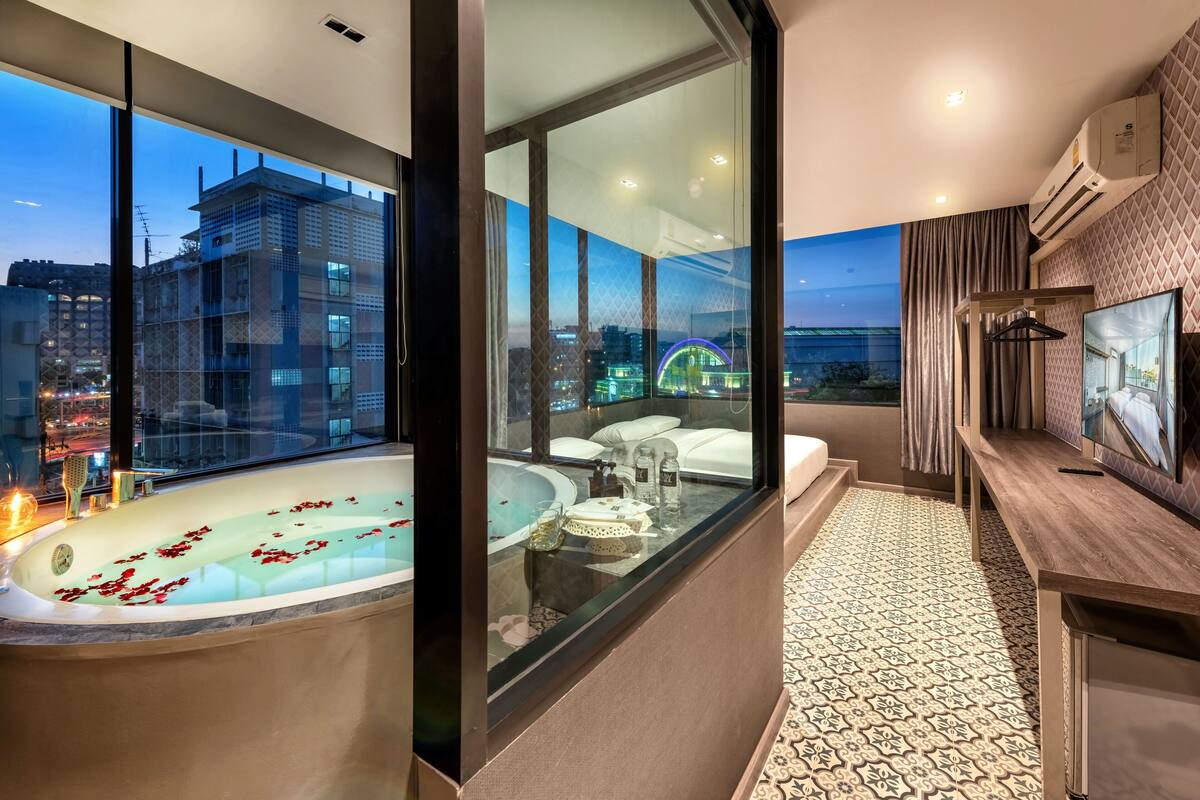Uma casa de banho moderna com banheira, toucador e uma janela ampla com vista para a cidade.