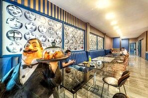 A restaurant with a long counter, blue striped walls, and a wall of framed faces. - Happy Station Bangkok (Bangkok)