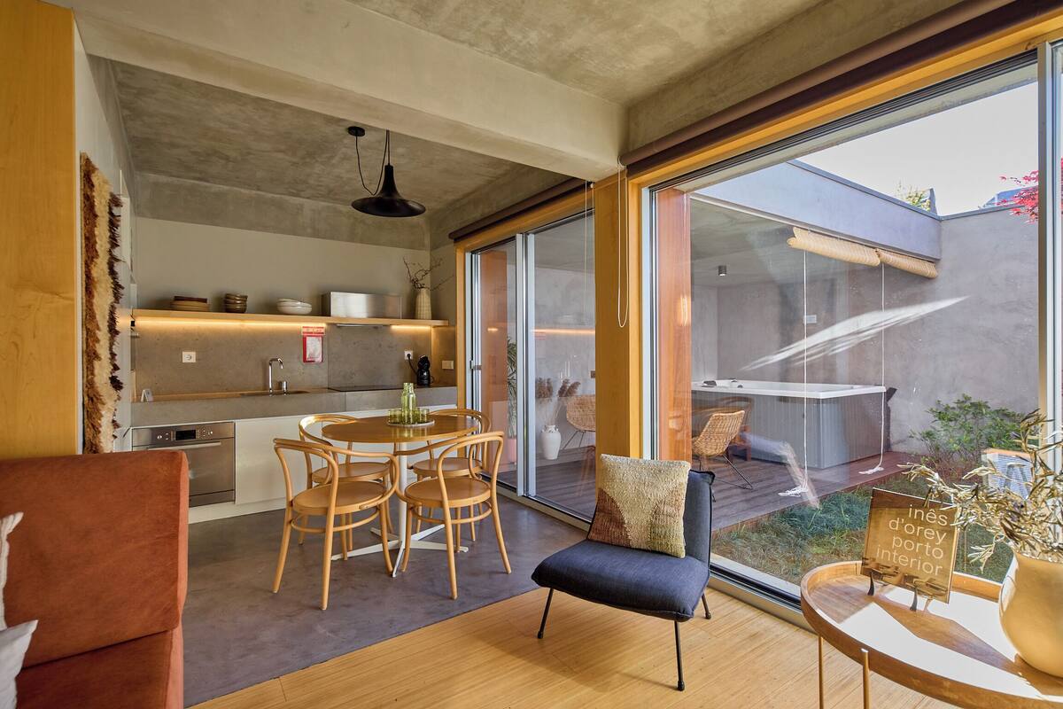 Una cocina moderna con comedor, ventanas amplias y una zona de estar acogedora con vistas al exterior.