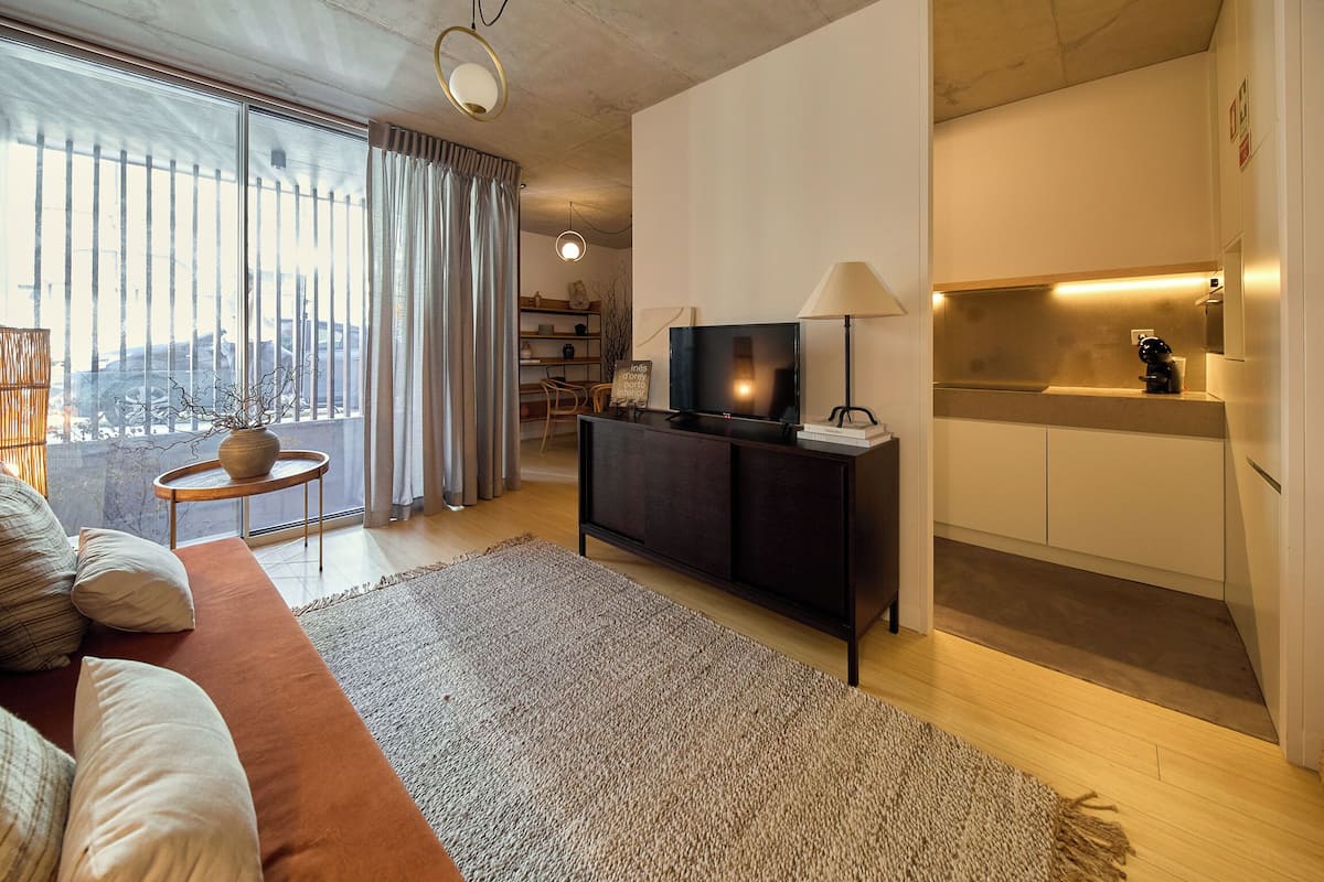 Una sala de estar moderna con un sofá, televisor y una mesita auxiliar.