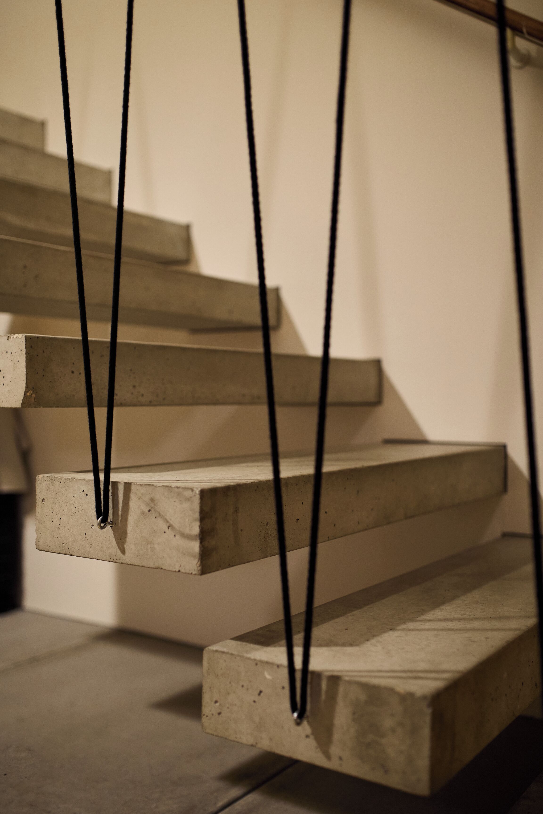 A set of concrete steps with black ropes.