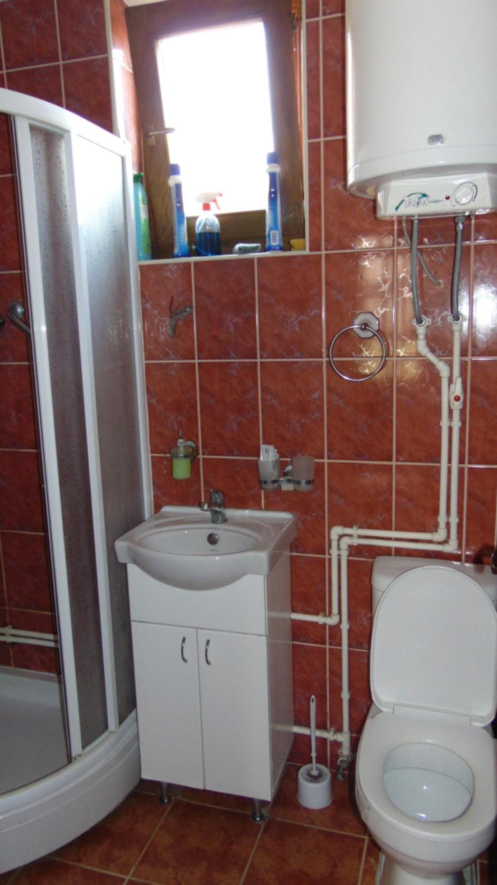 Uma casa de banho com lavatório, sanita e chuveiro.
