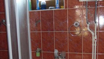 Uma casa de banho com lavatório, sanita e chuveiro.