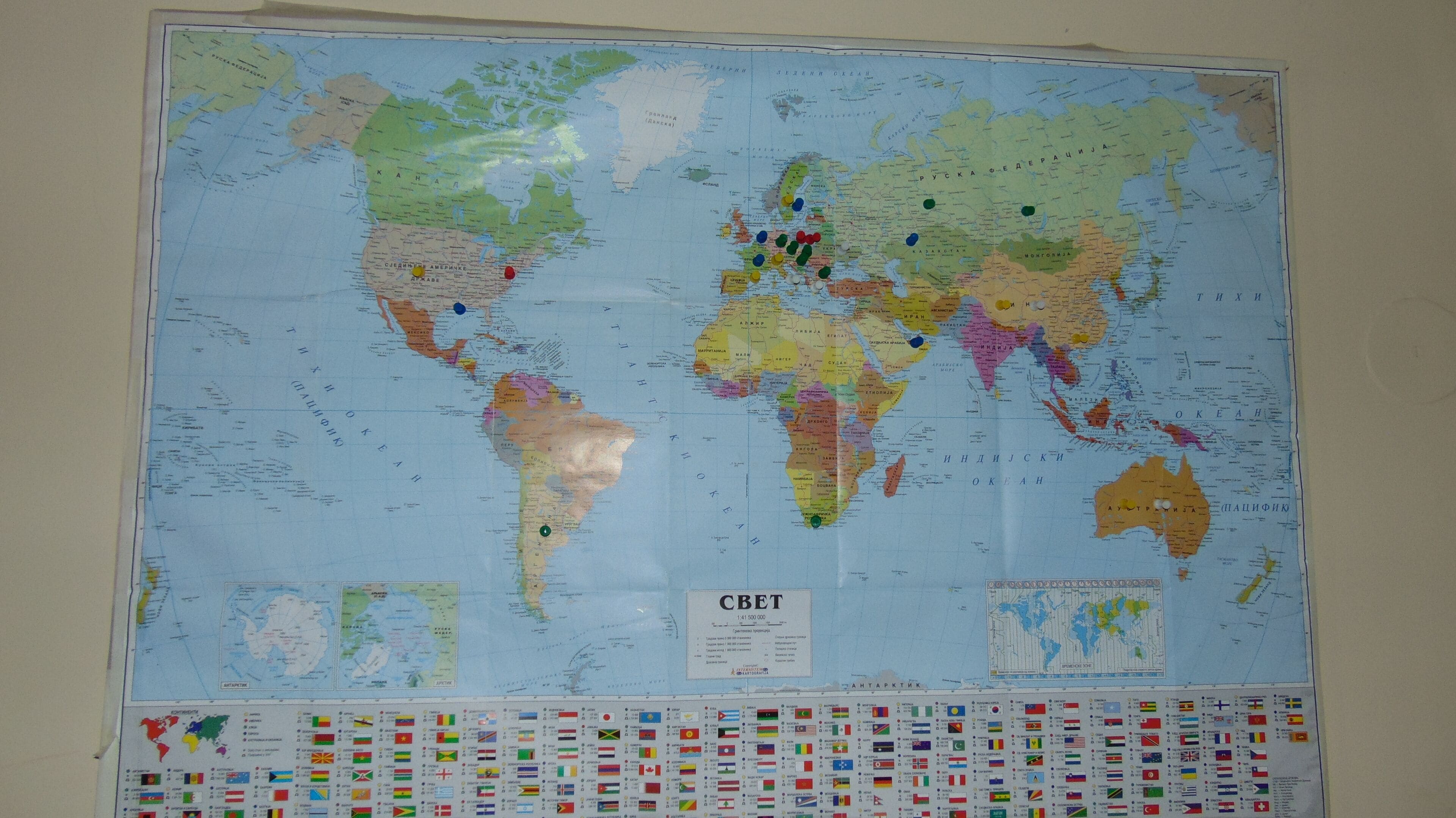 A world map with various colored pins, a legend, and flags.
