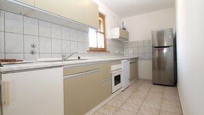 A compact kitchen with a built-in dishwasher, a stainless steel refrigerator, and a window above the sink. - Apartment 1624/16704 (Istria - Novigrad), 600m from the beach (Novigrad)
