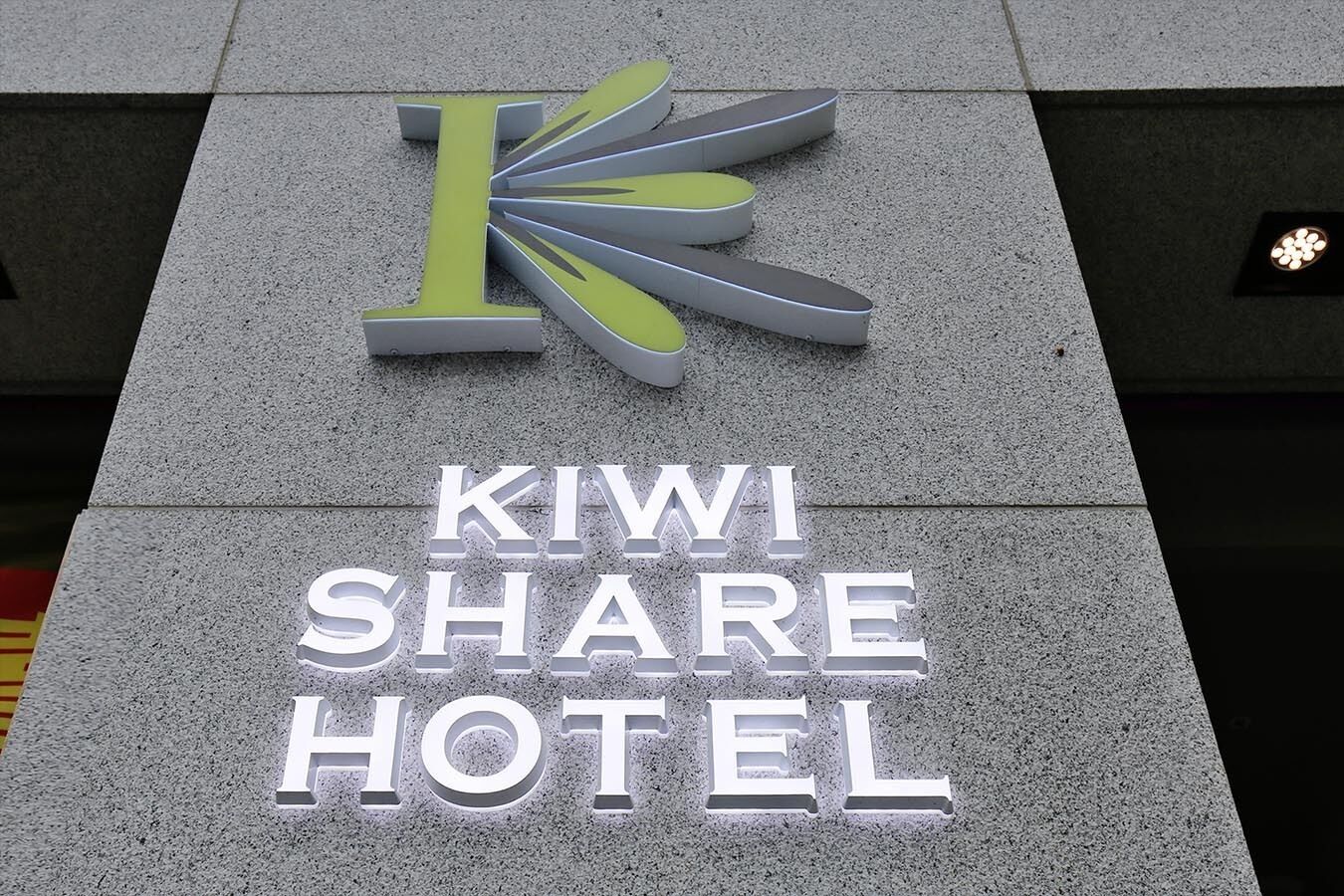 Señal del Kiwi Share Hotel, con una 'K' estilizada y el nombre del hotel en letras blancas grandes.